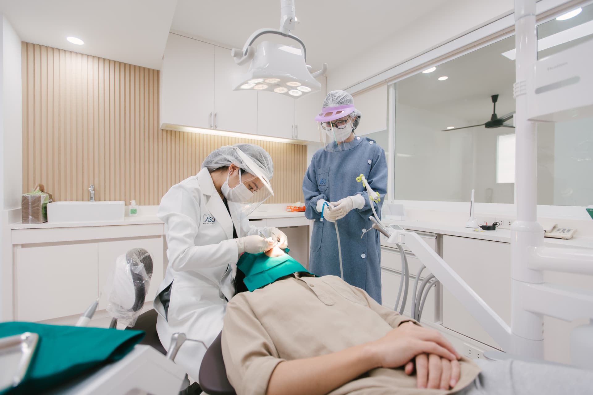 Dentist examining patient in treatment room